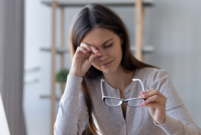 women rubbing eyes from dry eye symptoms